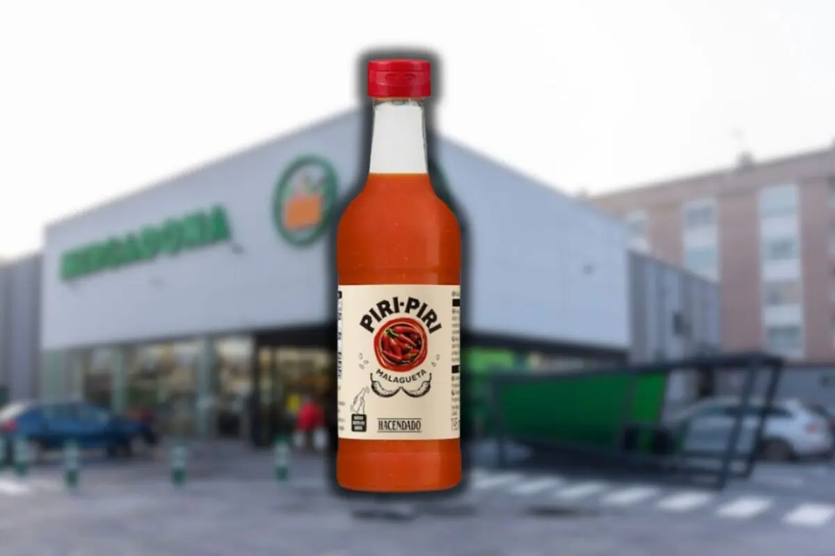 Botella de salsa picante Piri Piri Hacendado en primer plano con un supermercado Mercadona desenfocado de fondo