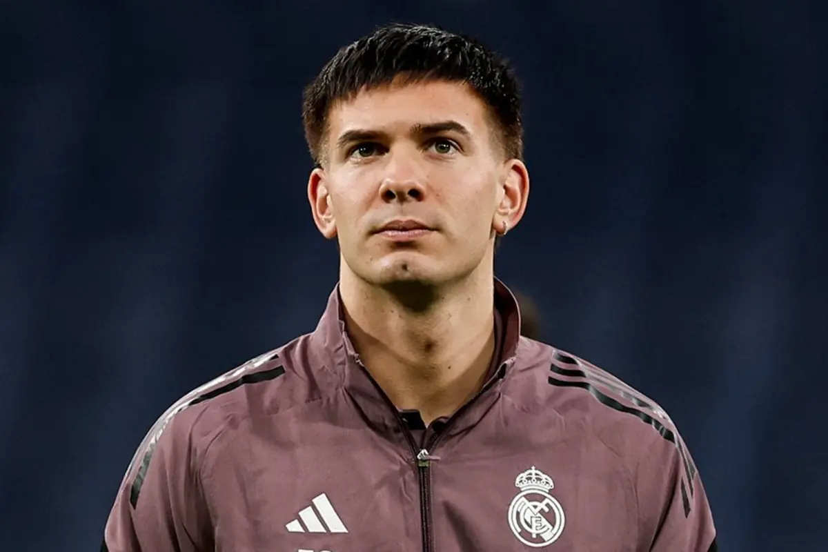 Futbolista amb xandall d’entrenament del Reial Madrid mirant al front sobre un fons fosc