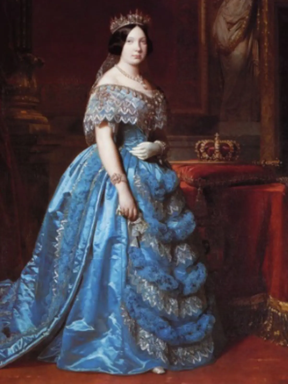 Retrat d’Isabel II amb vestit blau llarg i corona de joies dempeus al costat d’un coixí vermell amb una corona reial pintat per Federico Madrazo.