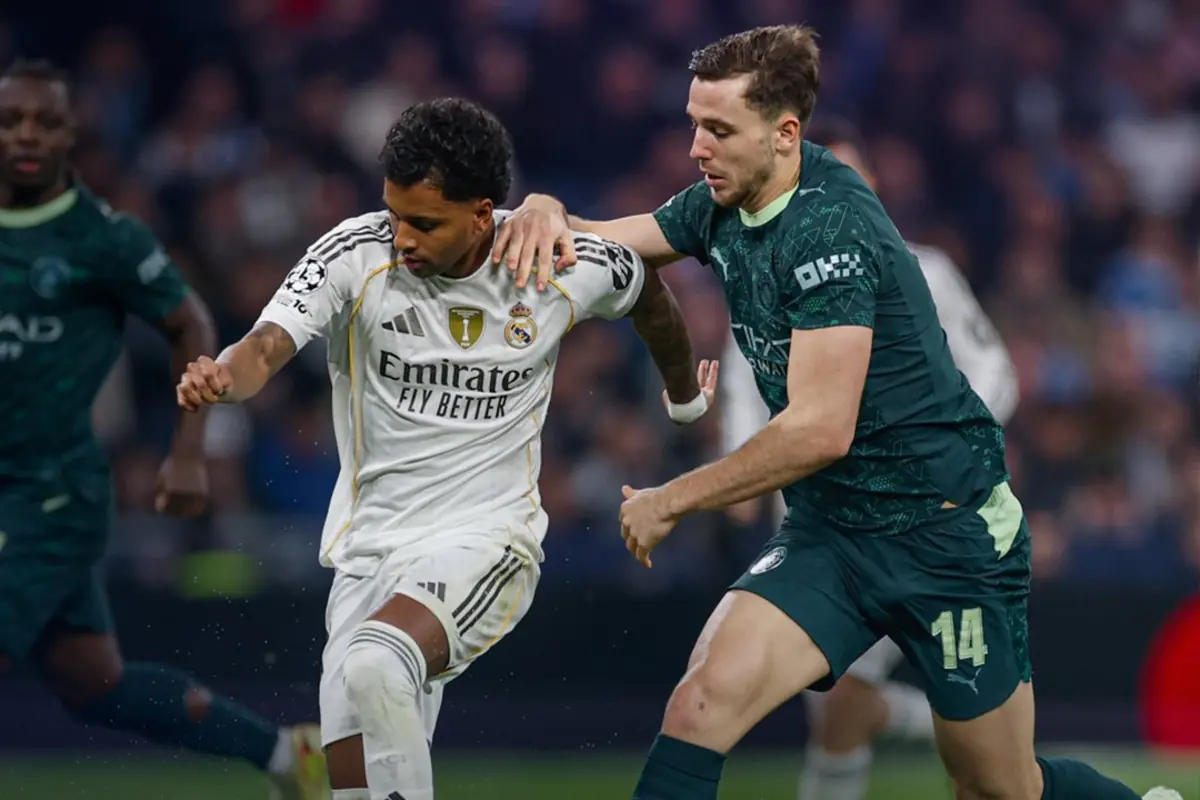 Dos futbolistes disputen la pilota durant un partit entre el Reial Madrid i el Manchester City.