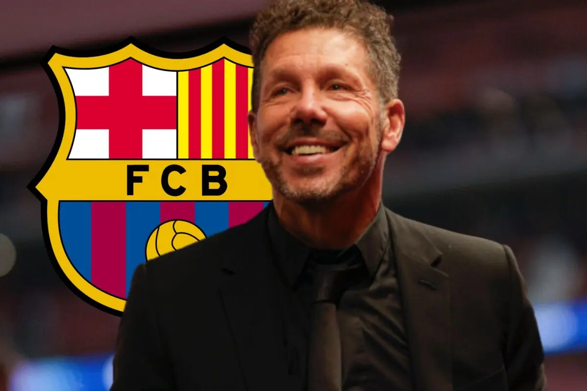 Home somrient amb barba i vestit fosc davant de l'escut del FC Barcelona