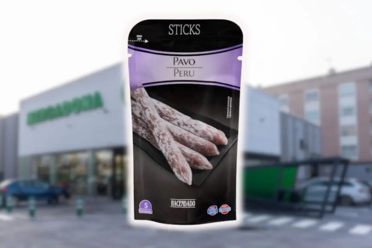 Envase de sticks de pavo marca Hacendado en primer plano con un supermercado Mercadona desenfocado de fondo