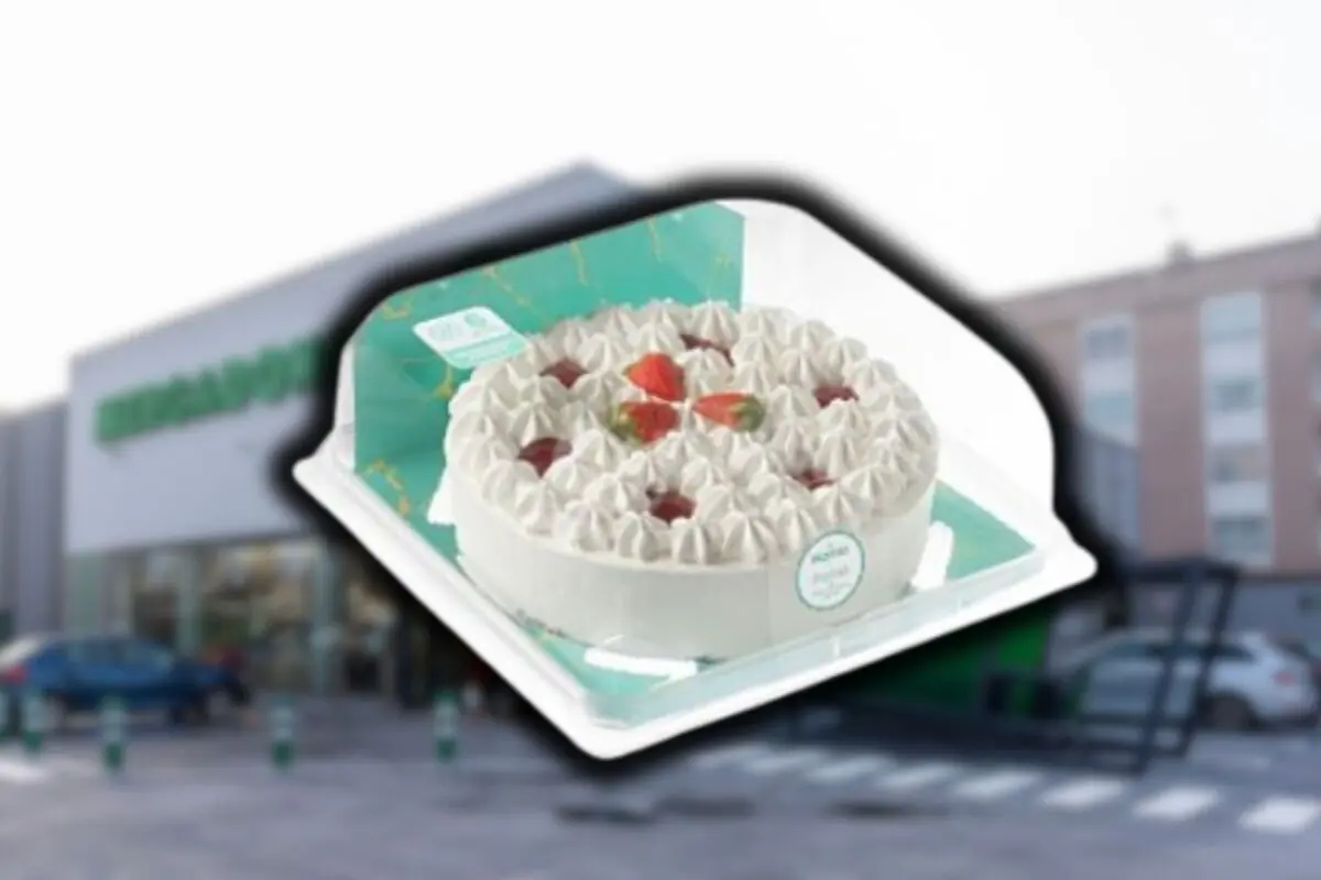 Pastel de nata y fresas con decoración de crema en un envase de plástico frente a una tienda