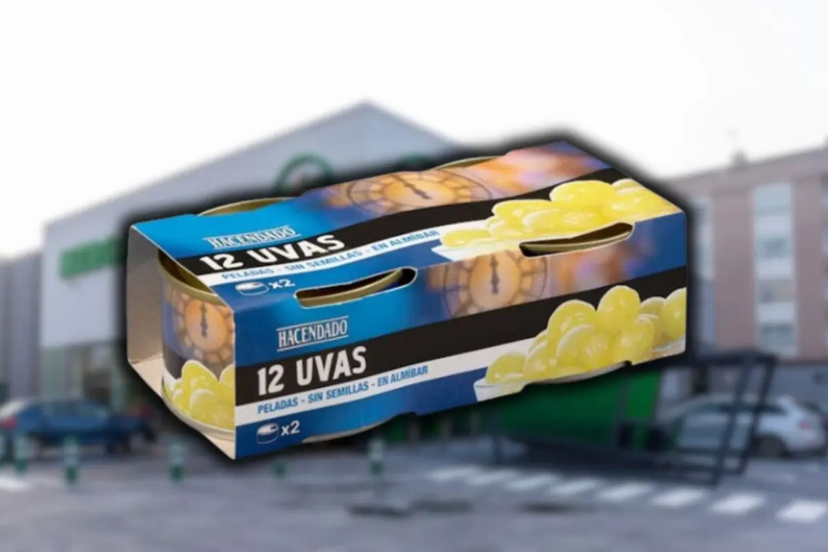 Caja de 12 uvas peladas sin semillas en almíbar de la marca Hacendado frente a un supermercado Mercadona desenfocado