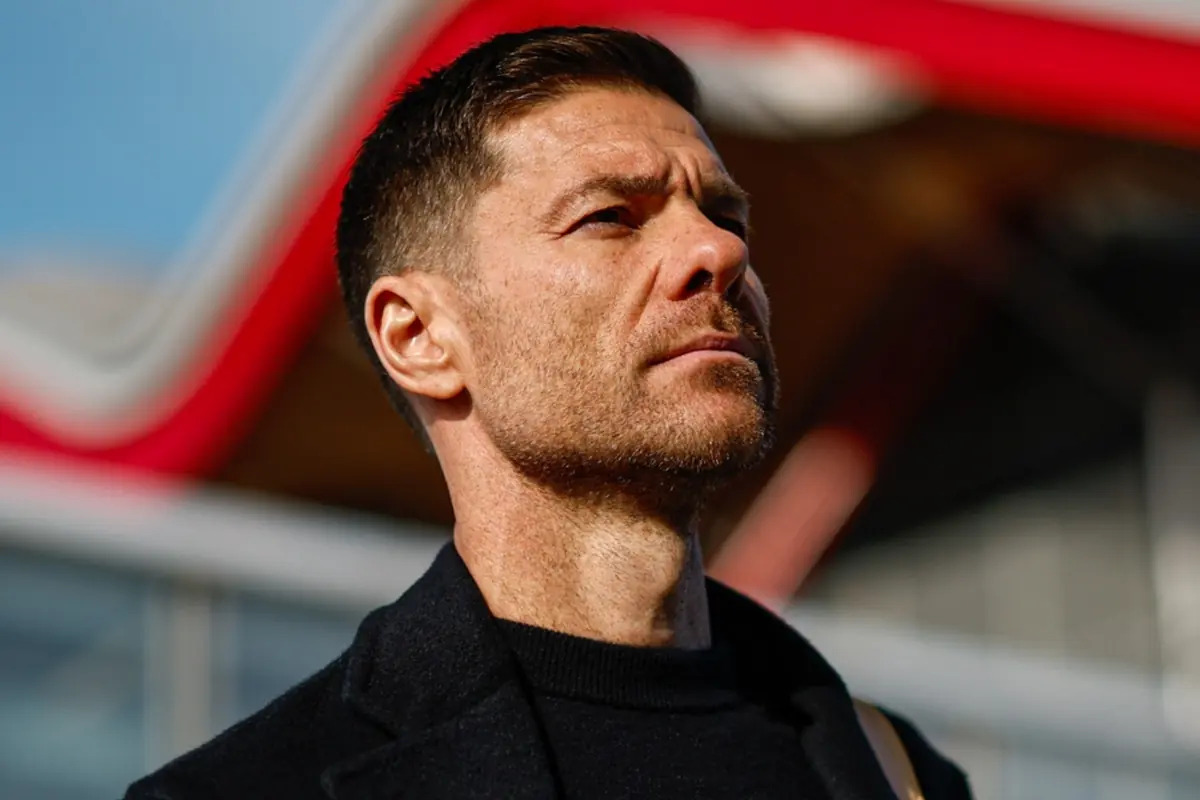 Hombre de cabello corto y barba ligera mirando hacia el horizonte con expresión seria y fondo desenfocado de colores rojo y azul Hombre de cabello corto y barba ligera mirando hacia el horizonte con expresión seria y fondo desenfocado de colores rojo y azul