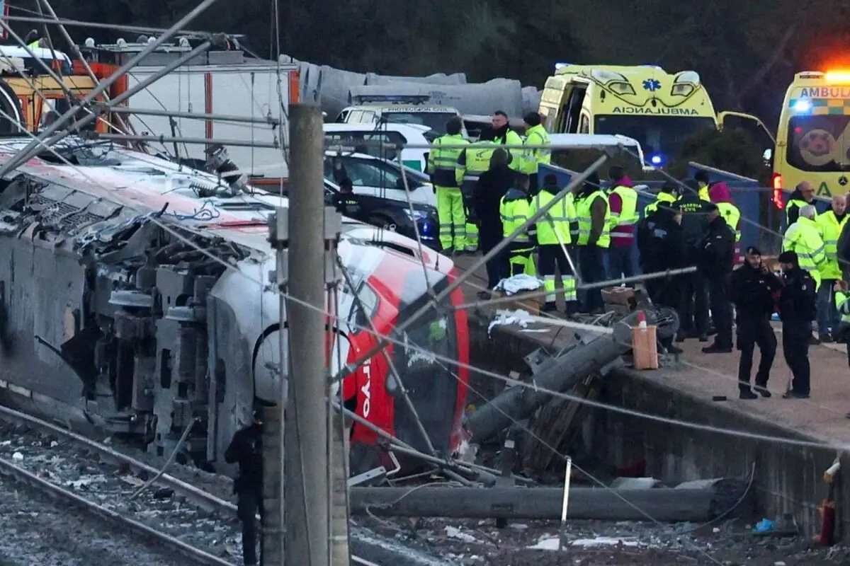Tren descarrilado y volcado junto a la vía con numerosos equipos de emergencia y ambulancias atendiendo el accidente Tren descarrilado y volcado junto a la vía con numerosos equipos de emergencia y ambulancias atendiendo el accidente