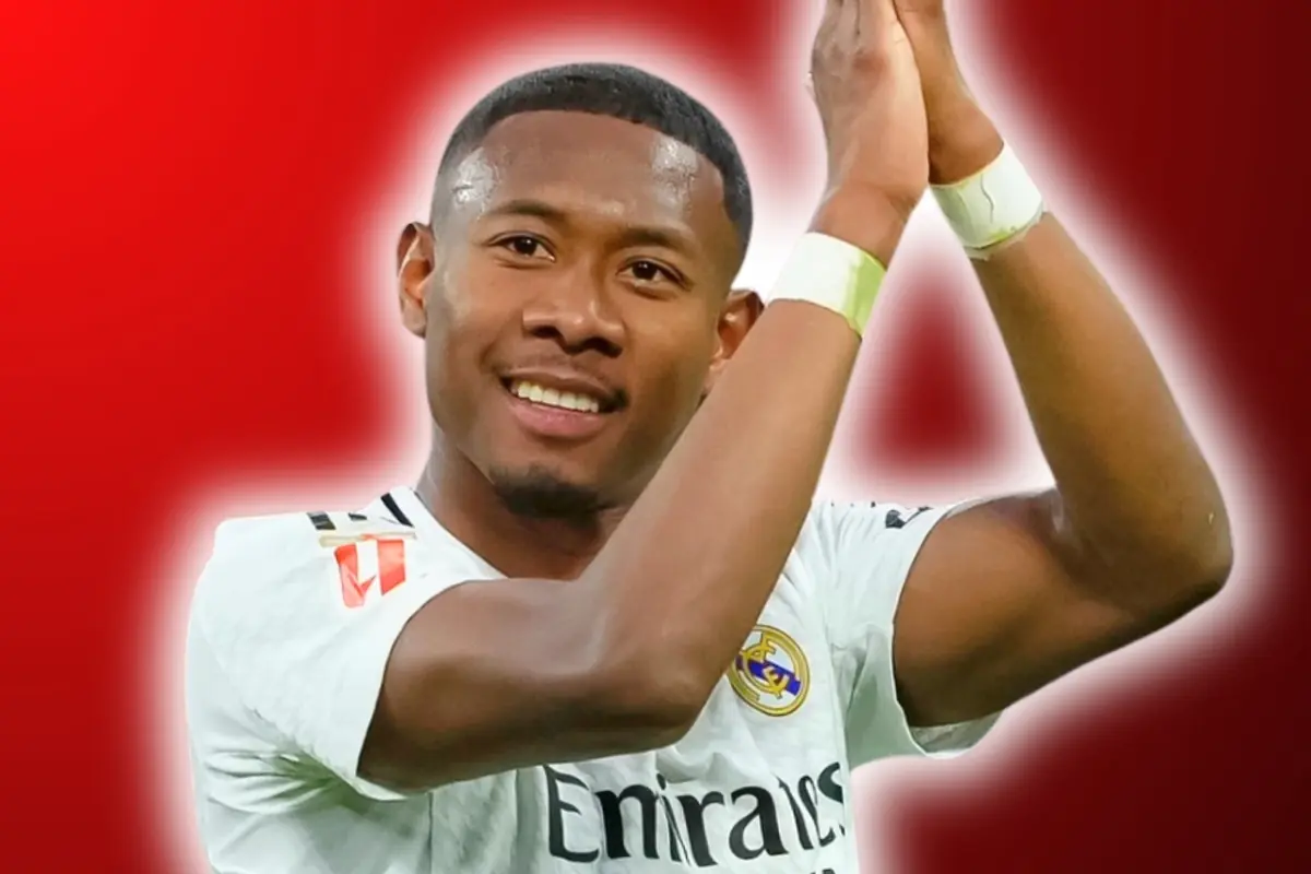 Futbolista con camiseta blanca del Real Madrid aplaudiendo sonriente sobre un fondo rojo difuminado