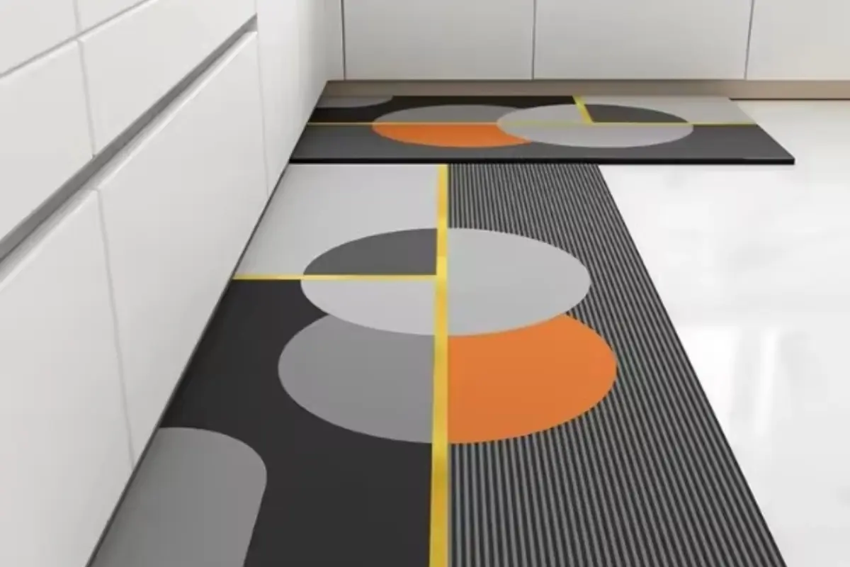Alfombras de cocina modernas con diseño geométrico en tonos gris negro naranja y amarillo colocadas frente a muebles blancos