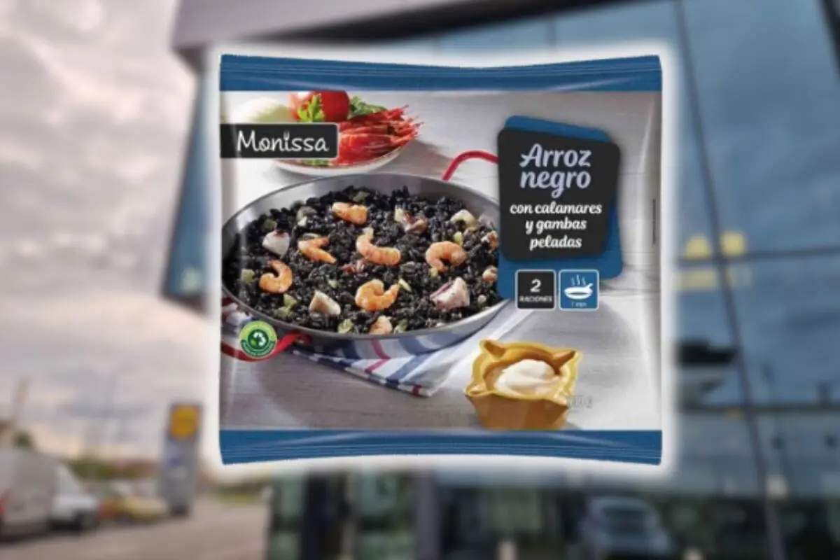Envase de arroz negro congelado marca Monissa con calamares y gambas peladas mostrado en primer plano sobre un fondo desenfocado de supermercado