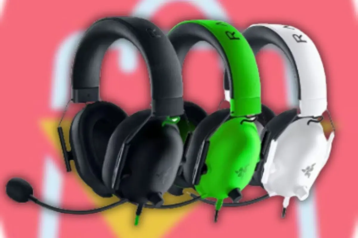 Auriculares gamer con micrófono en colores negro verde y blanco sobre fondo rosa desenfocado