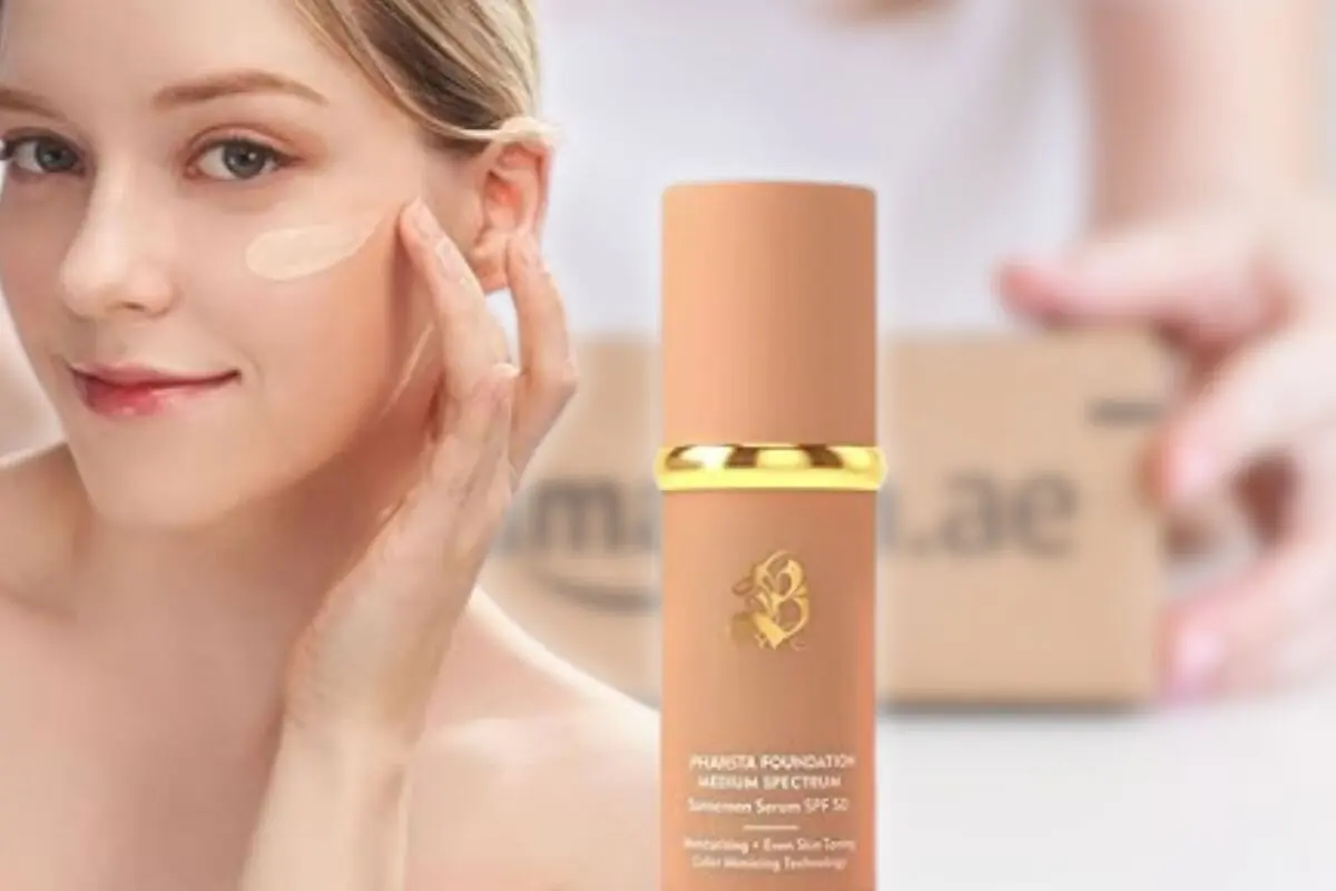 Mujer aplicando base de maquillaje en el rostro junto a un frasco de sérum con protector solar SPF 50