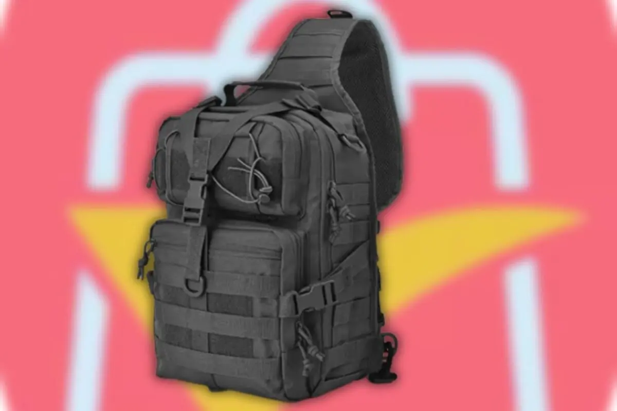 Mochila táctica negra de un solo tirante con múltiples compartimentos y correas sobre fondo rosa con figura amarilla y blanca desenfocada Mochila táctica negra de un solo tirante con múltiples compartimentos y correas sobre fondo rosa con figura amarilla y blanca desenfocada