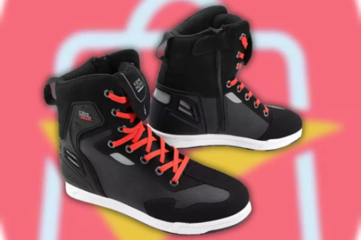 Tenis negros de caña alta con agujetas rojas sobre fondo rosa difuminado