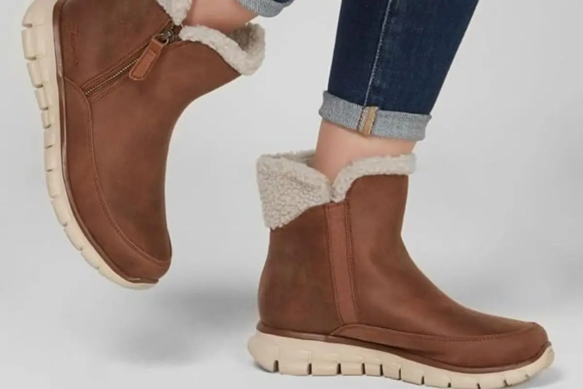 Botas cortas marrones con forro de borreguito y suela blanca flexibles usadas con pantalones vaqueros doblados