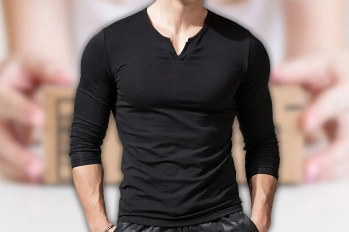 Hombre vistiendo camiseta negra ajustada de manga larga con cuello en V sobre fondo desenfocado