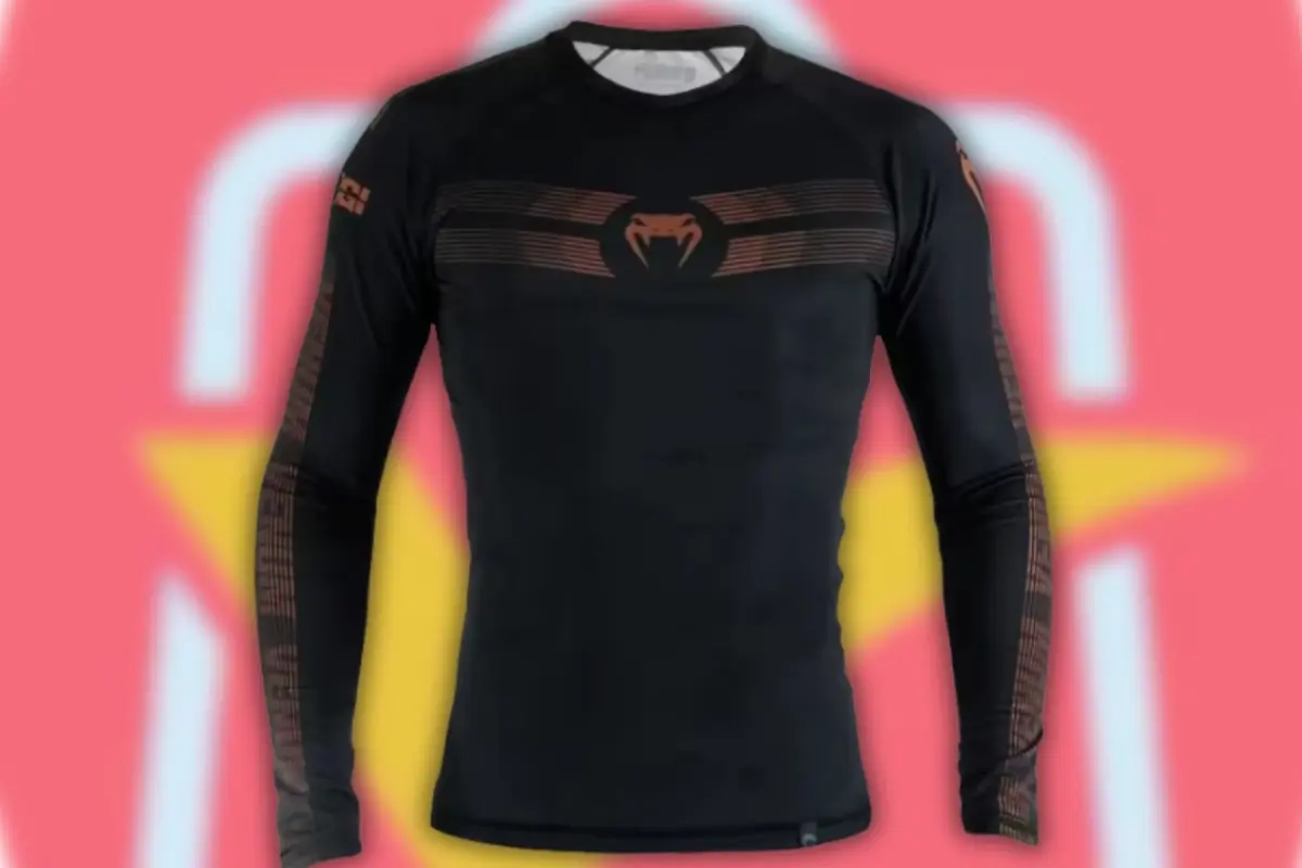 Playera deportiva negra de manga larga con diseño de serpiente en el pecho sobre fondo rojo y amarillo