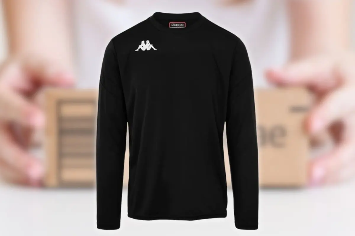 Sudadera negra de manga larga con logo blanco de Kappa en el pecho sobre fondo desenfocado