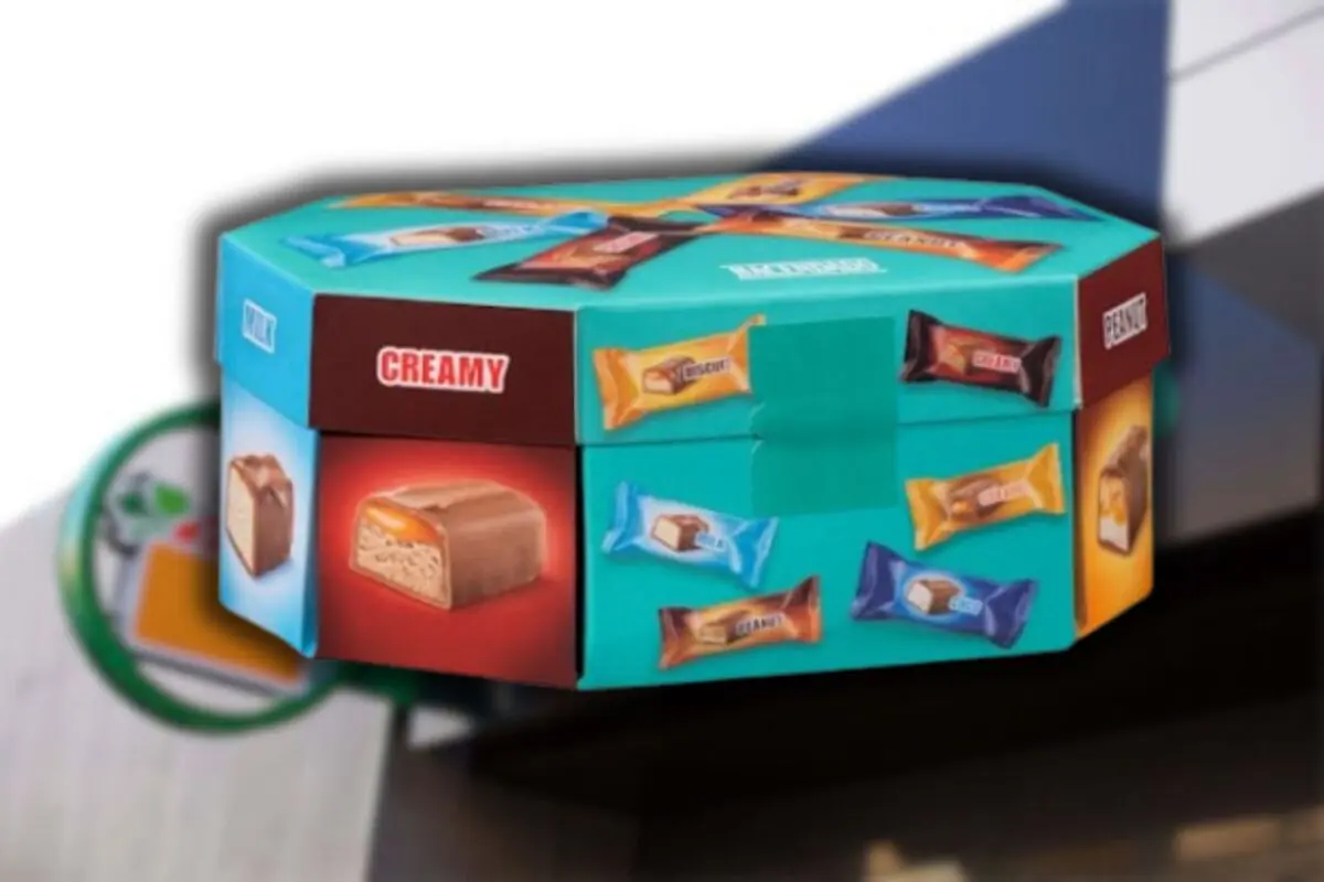 Caja octagonal de chocolates surtidos con envolturas de colores y la palabra CREAMY en uno de los lados