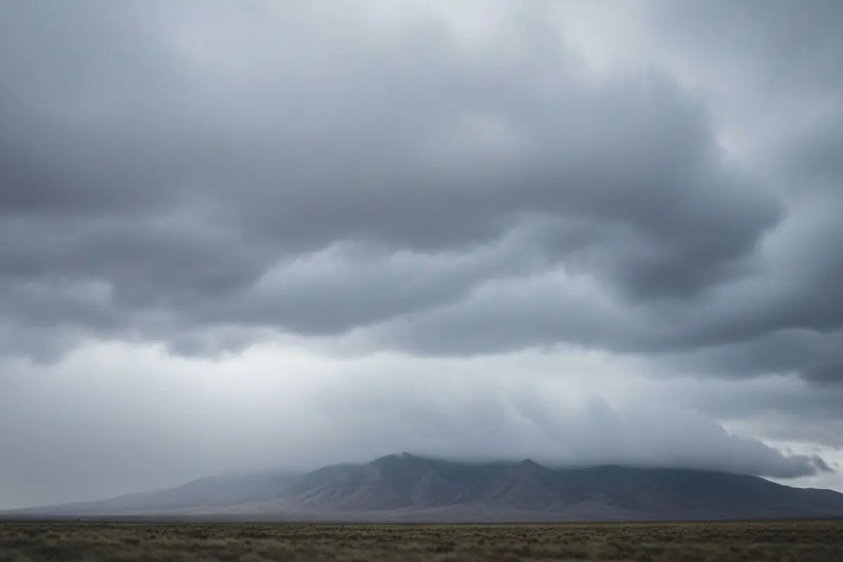 Paisatge de muntanya semidesèrtica coberta per núvols grisos de tempesta.