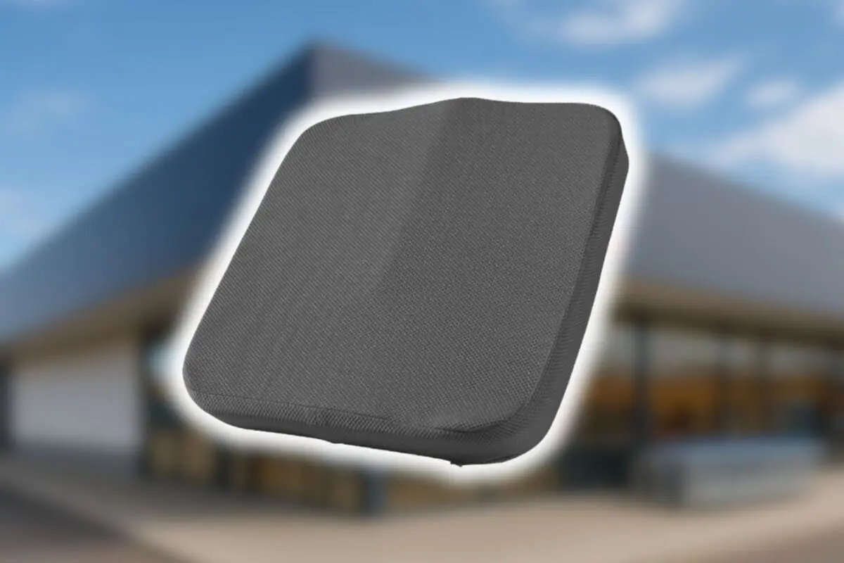 Cojín ergonómico gris flotando sobre un fondo desenfocado de una tienda Aldi.