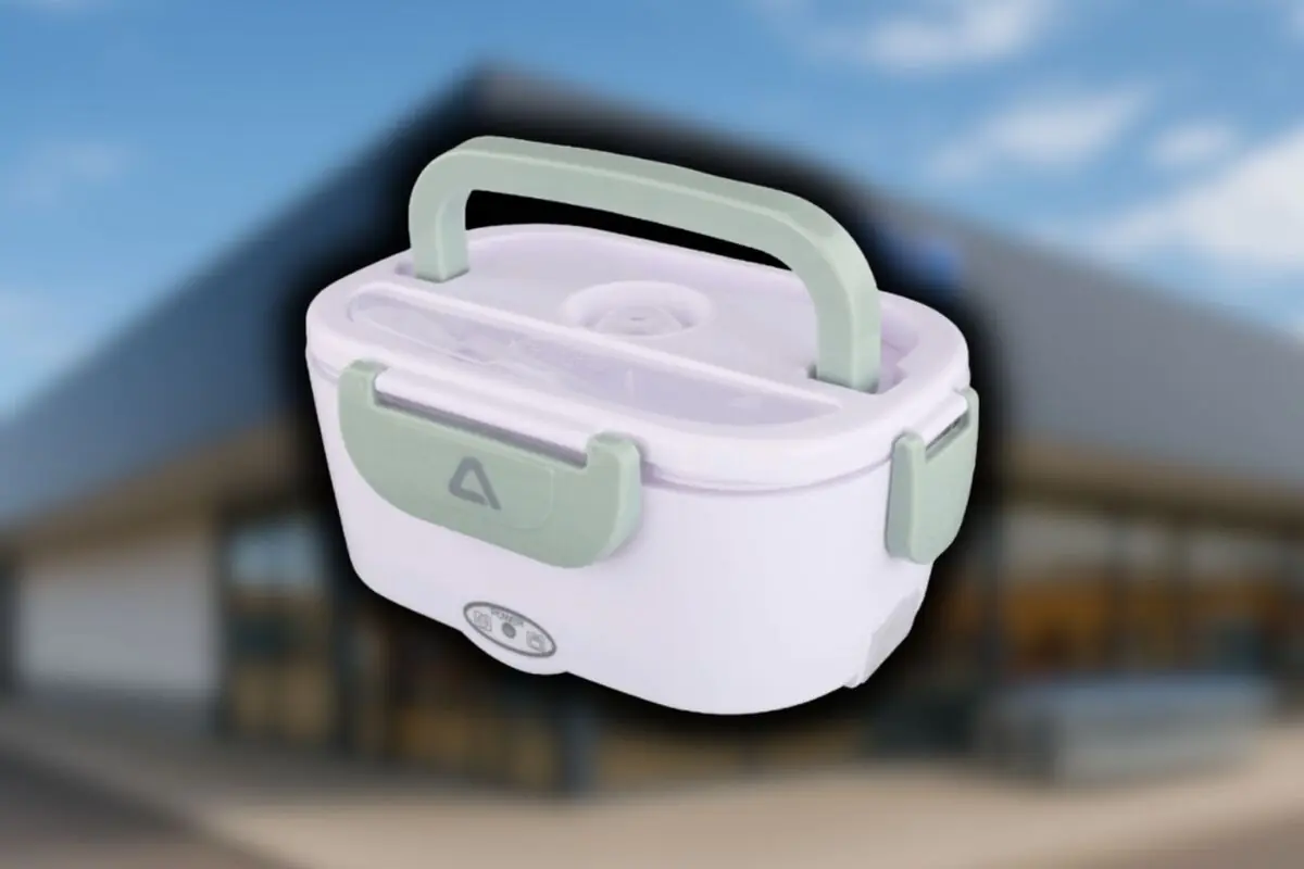 Lonchera eléctrica portátil blanca con asas y cierres verdes sobre fondo desenfocado de una tienda Aldi.