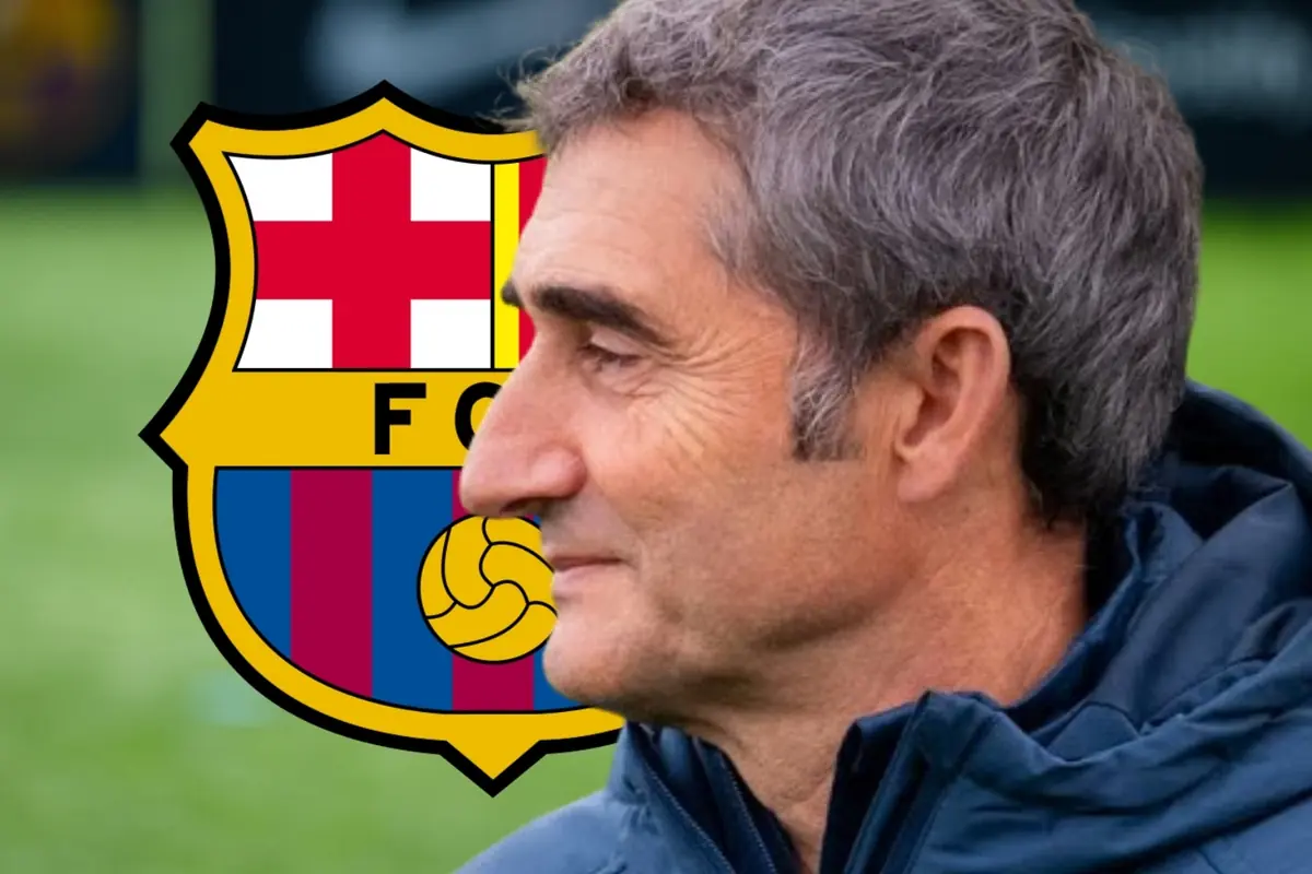 Entrenador de futbol de perfil amb jaqueta blava davant de l’escut del FC Barcelona sobre un camp de joc