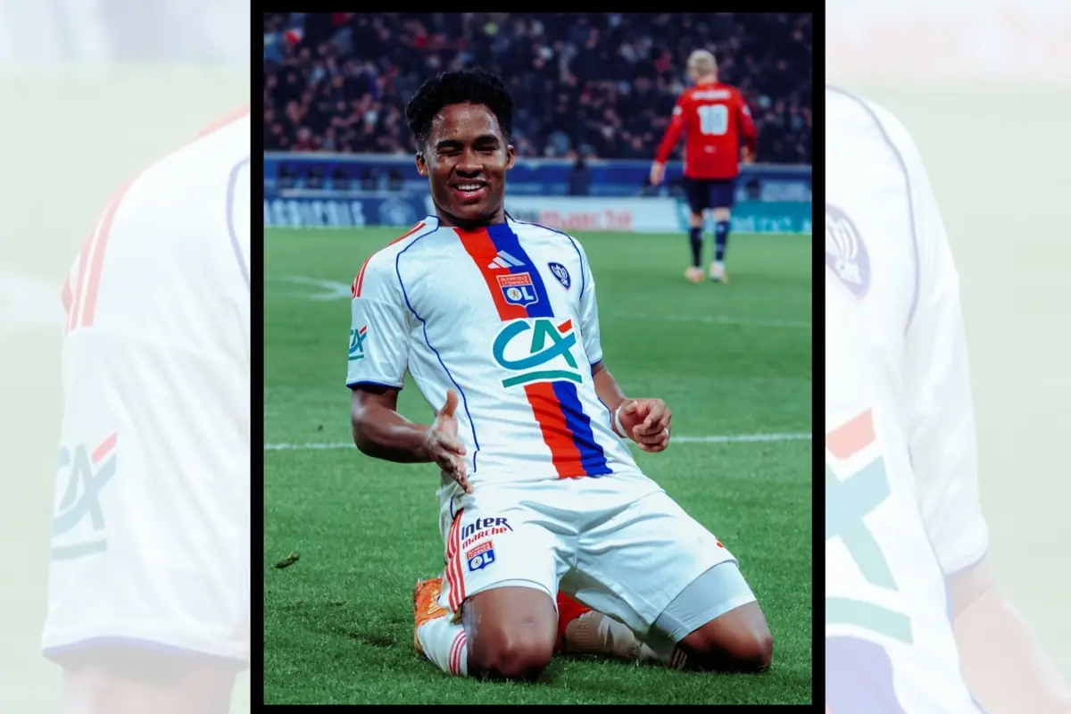 Futbolista del Olympique de Lyon celebrando un gol arrodillado sobre el césped durante un partido