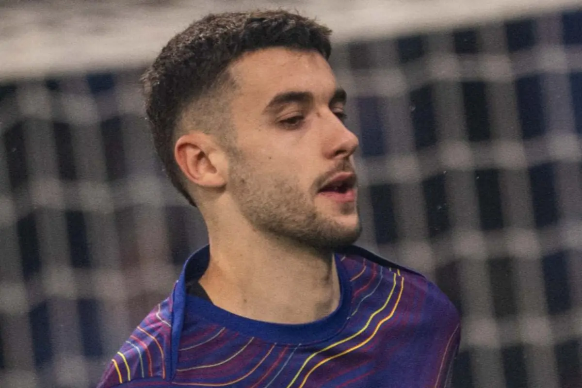 Porter de futbol del FC Barcelona amb guants i samarreta d’escalfament morada davant de la porteria durant un partit