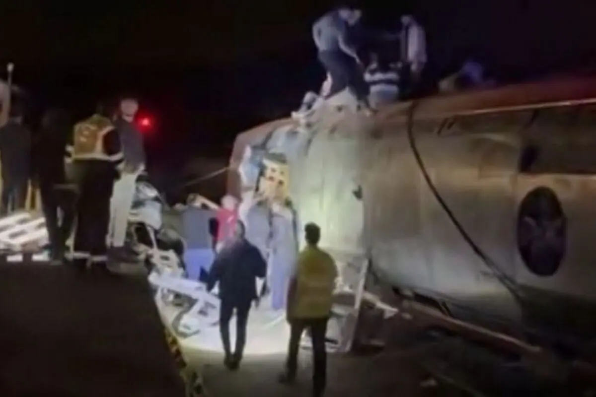 Rescat nocturn de persones al voltant d’un vagó de tren bolcat il·luminat per focus després d’un accident.