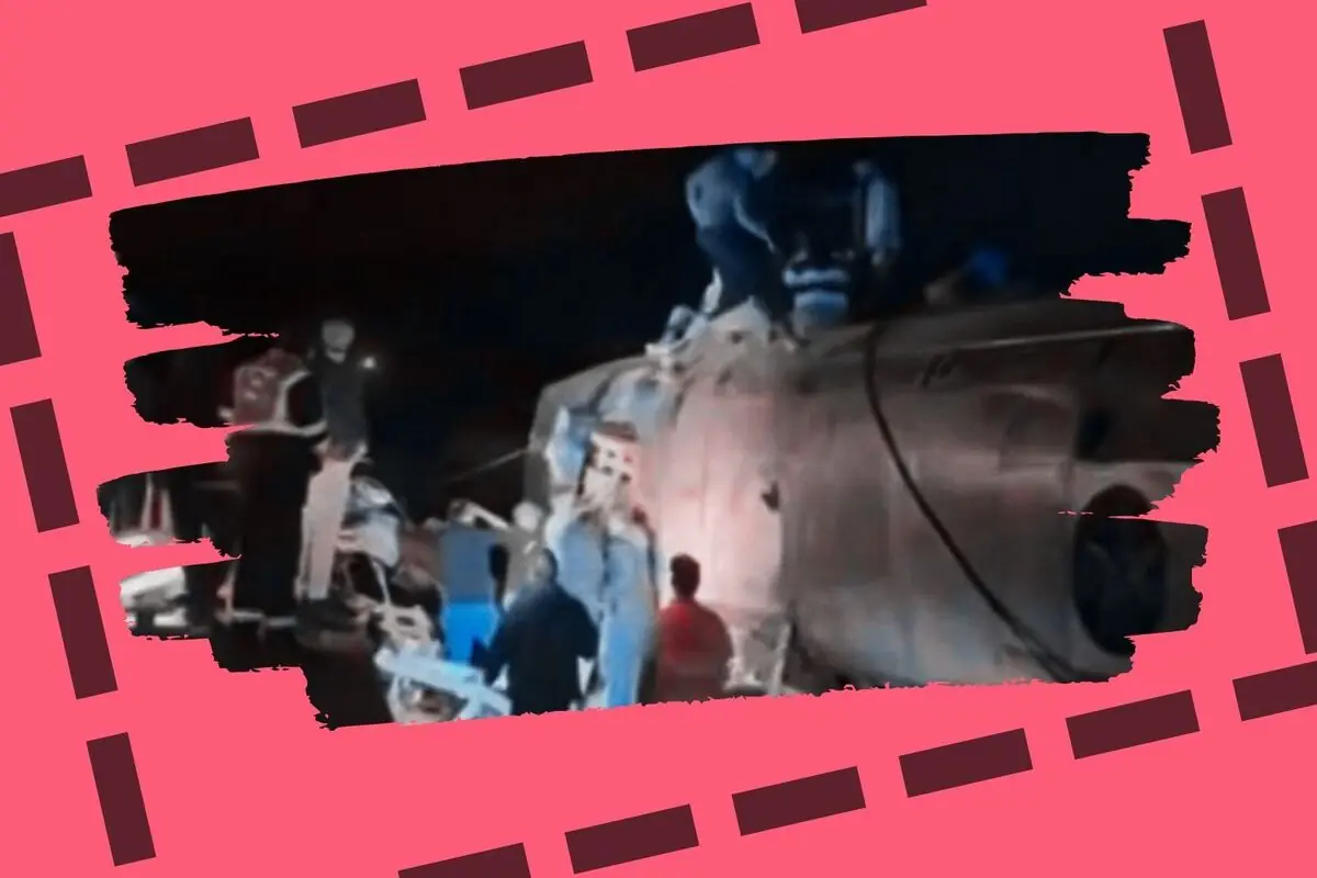 Els equips de rescat treballen de nit al voltant d’un vehicle bolcat en un accident envoltat per un marc rosa amb línies fosques.