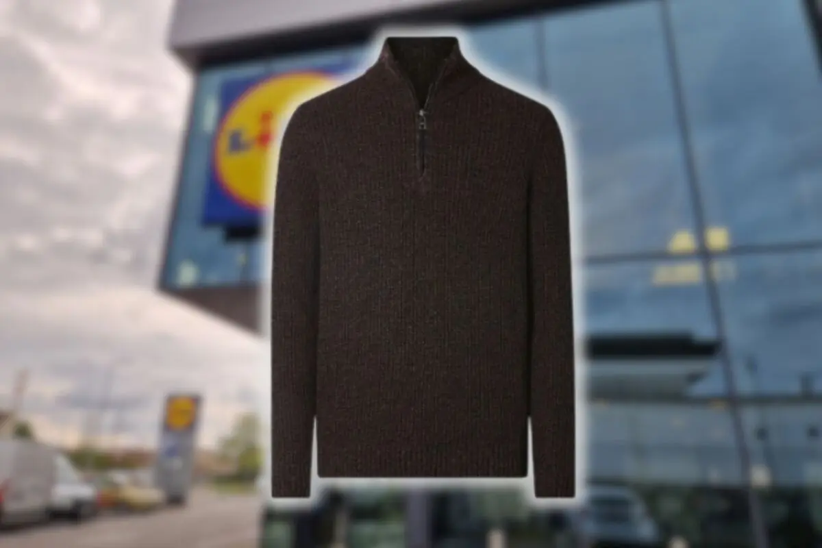 Jersey de punto marrón con cremallera corta en el cuello sobre un fondo desenfocado de supermercado