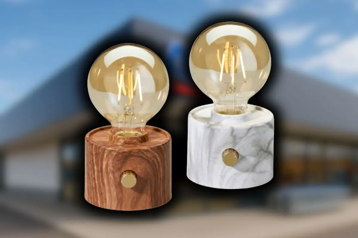 Dos lámparas de mesa con bombilla esférica de filamento sobre bases cilíndricas de Aldi, una de madera y otra de efecto mármol con fondo desenfocado.