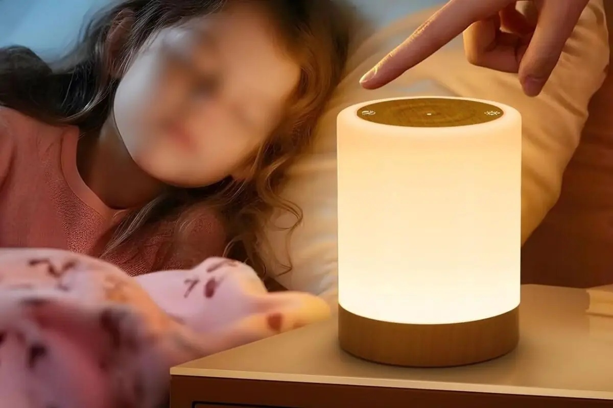 Niña durmiendo junto a una lámpara de mesa cilíndrica de luz cálida que se enciende al tacto