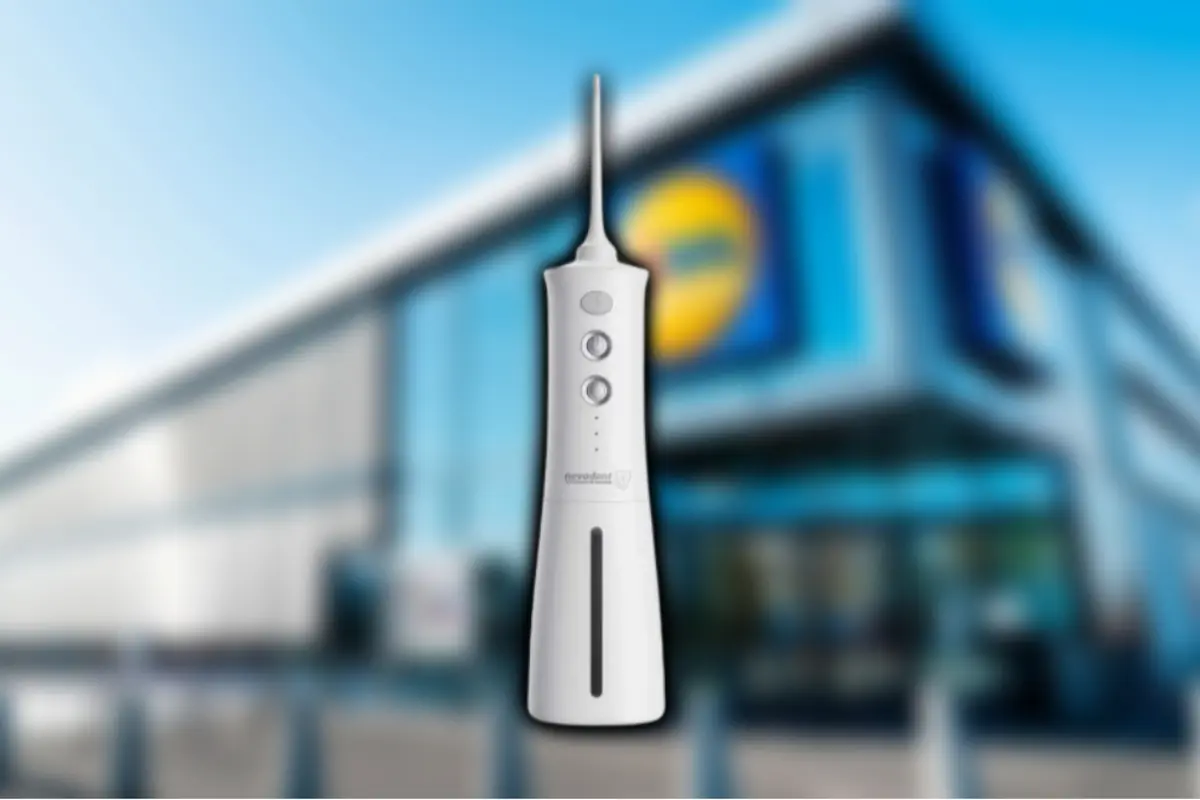Irrigador dental eléctrico blanco en primer plano con fachada de supermercado desenfocada de fondo Irrigador dental eléctrico blanco en primer plano con fachada de supermercado desenfocada de fondo