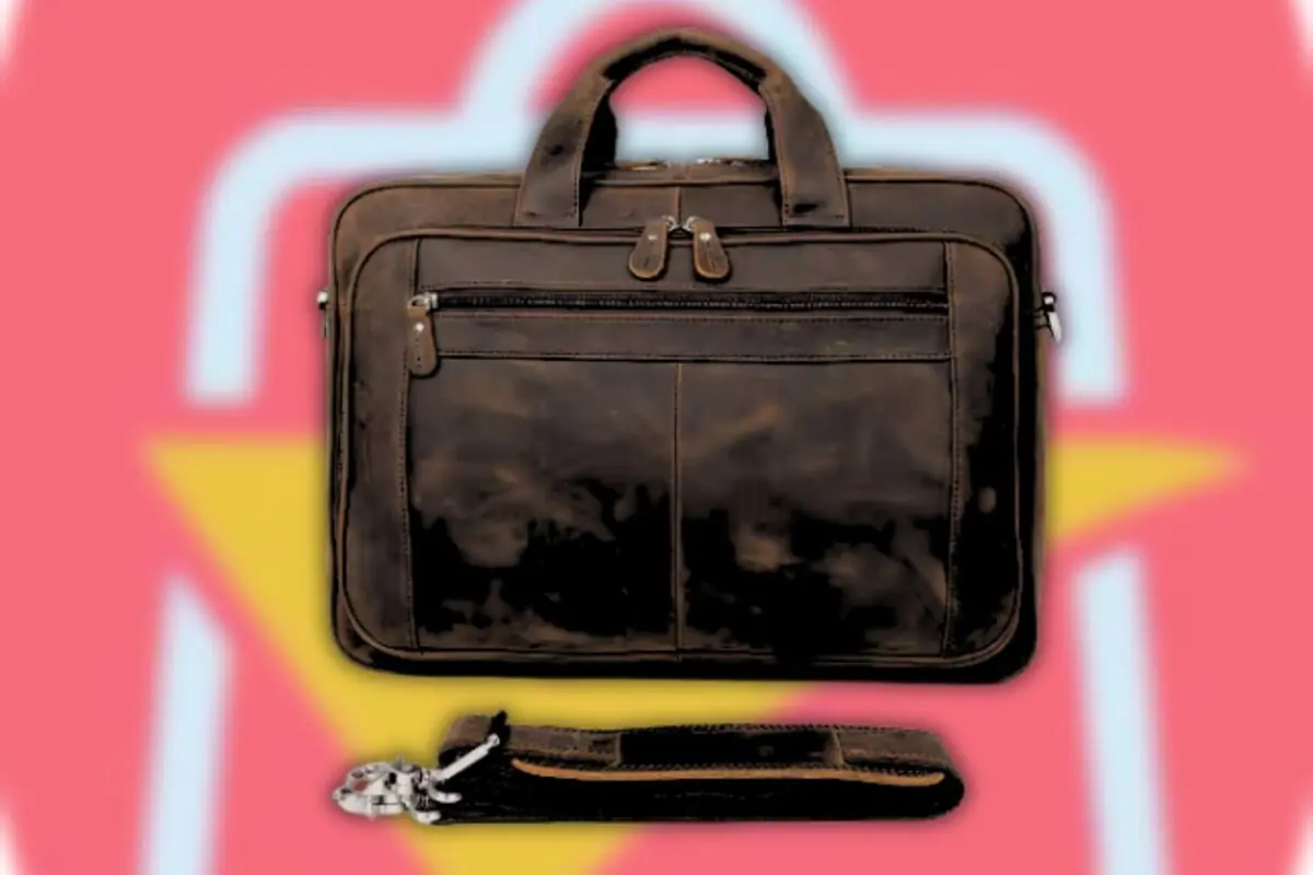 Maletín de cuero marrón con asas cortas y correa desmontable sobre fondo rosa con figura amarilla Maletín de cuero marrón con asas cortas y correa desmontable sobre fondo rosa con figura amarilla