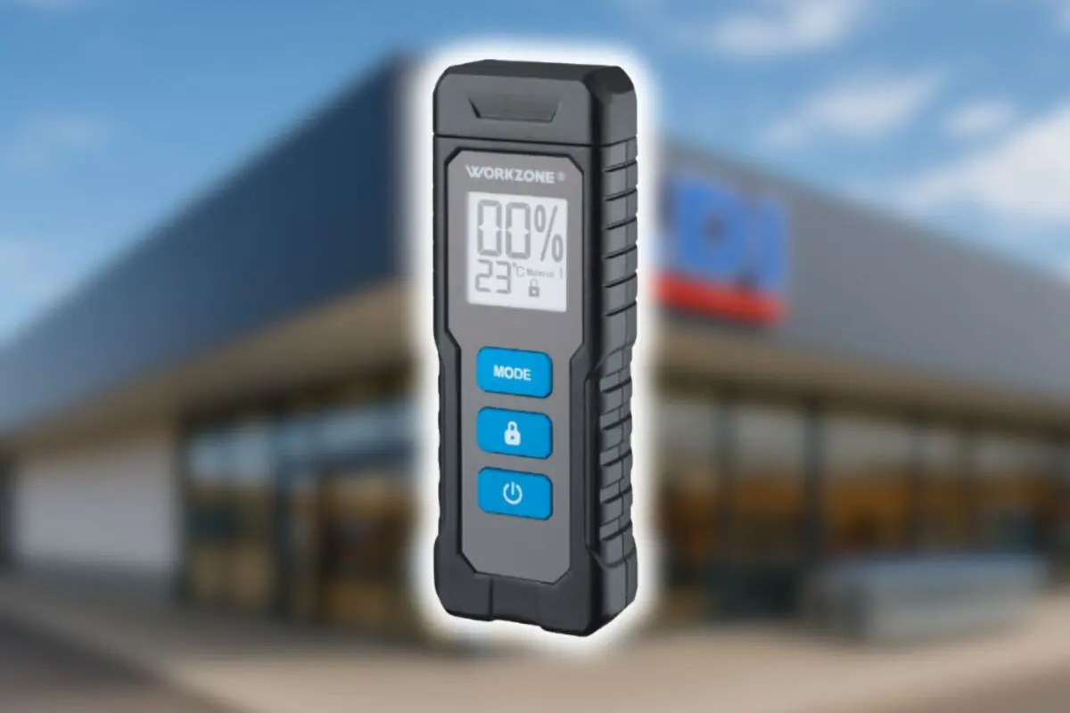 Medidor digital de humedad Workzone de Aldi en primer plano sobre fondo desenfocado de fachada de un supermercado de la cadena.