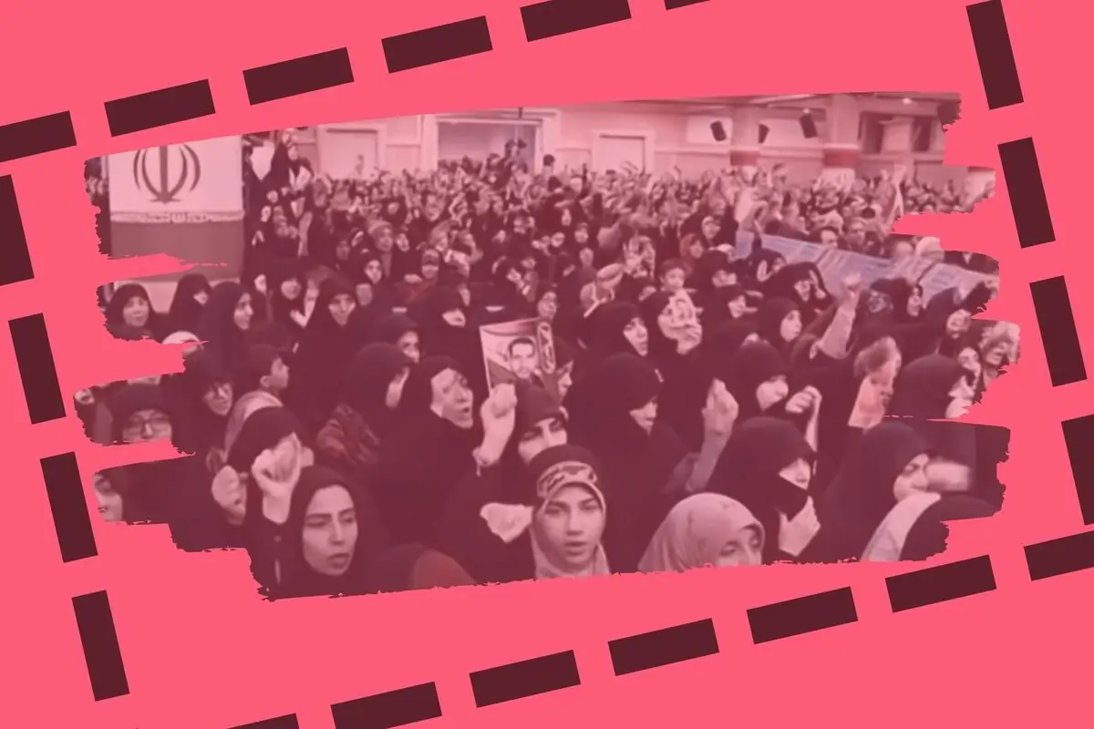 Multitud de dones amb vel alçant el puny en una manifestació a l’Iran en un recinte tancat amb disseny gràfic en tons roses al voltant.