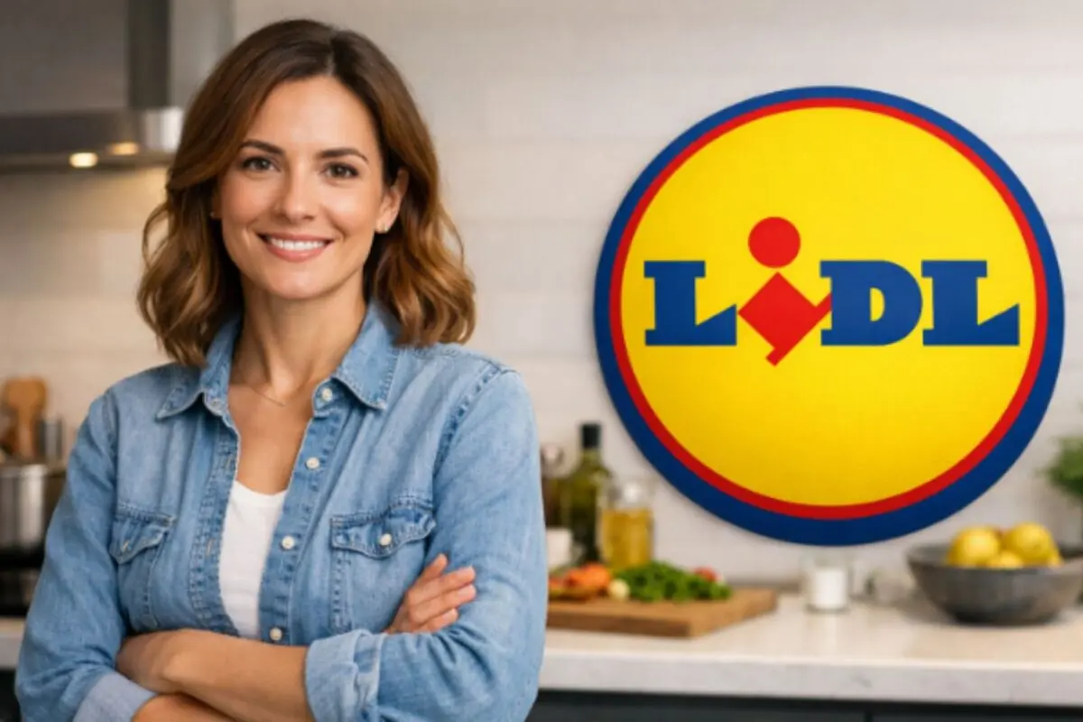 Smiling woman in a denim jersey in a kitchen next to a large round logo of the Lidl supermarket chain.