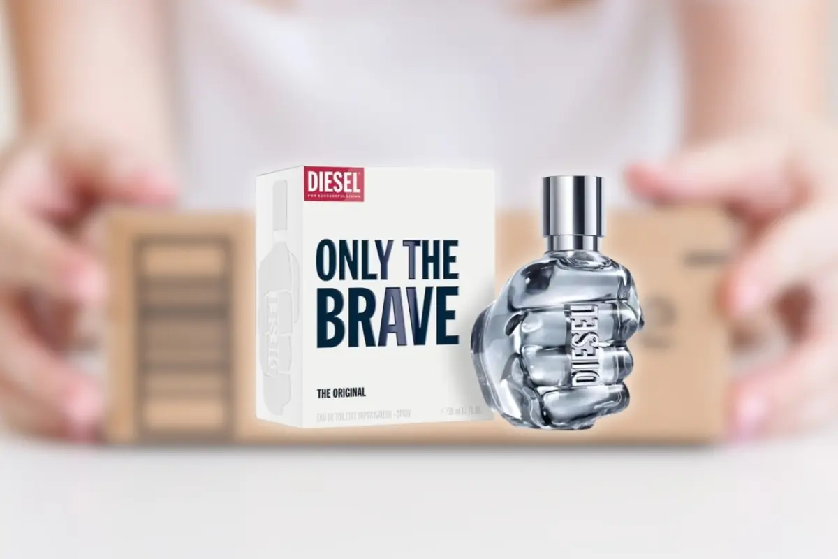 Montaje con el perfume Diesel Only The Brave con frasco en forma de puño metálico junto a su caja blanca sobre fondo desenfocado