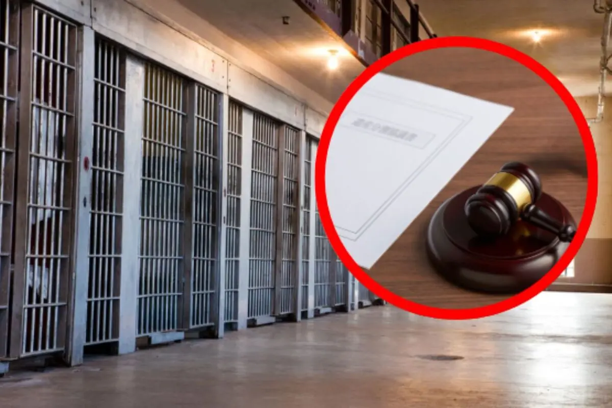 Passadís de cel·les de presó amb un cercle vermell que ressalta un mall de jutge i documents legals sobre una taula.