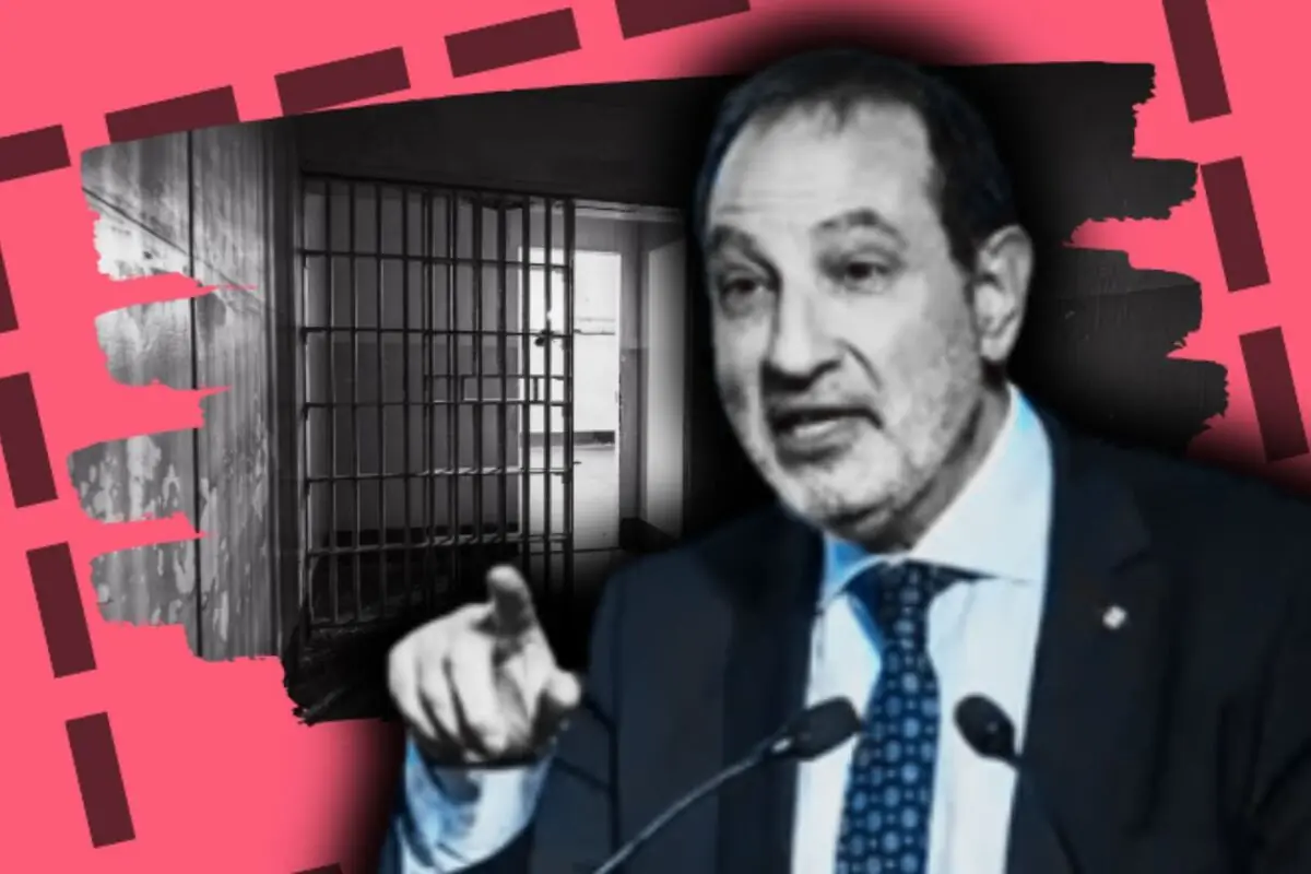 Ramon Espadaler, vestit amb vestit, parlant davant d’un micròfon amb un gest assenyalant i al fons una cel·la de presó en blanc i negre sobre un disseny gràfic rosa.