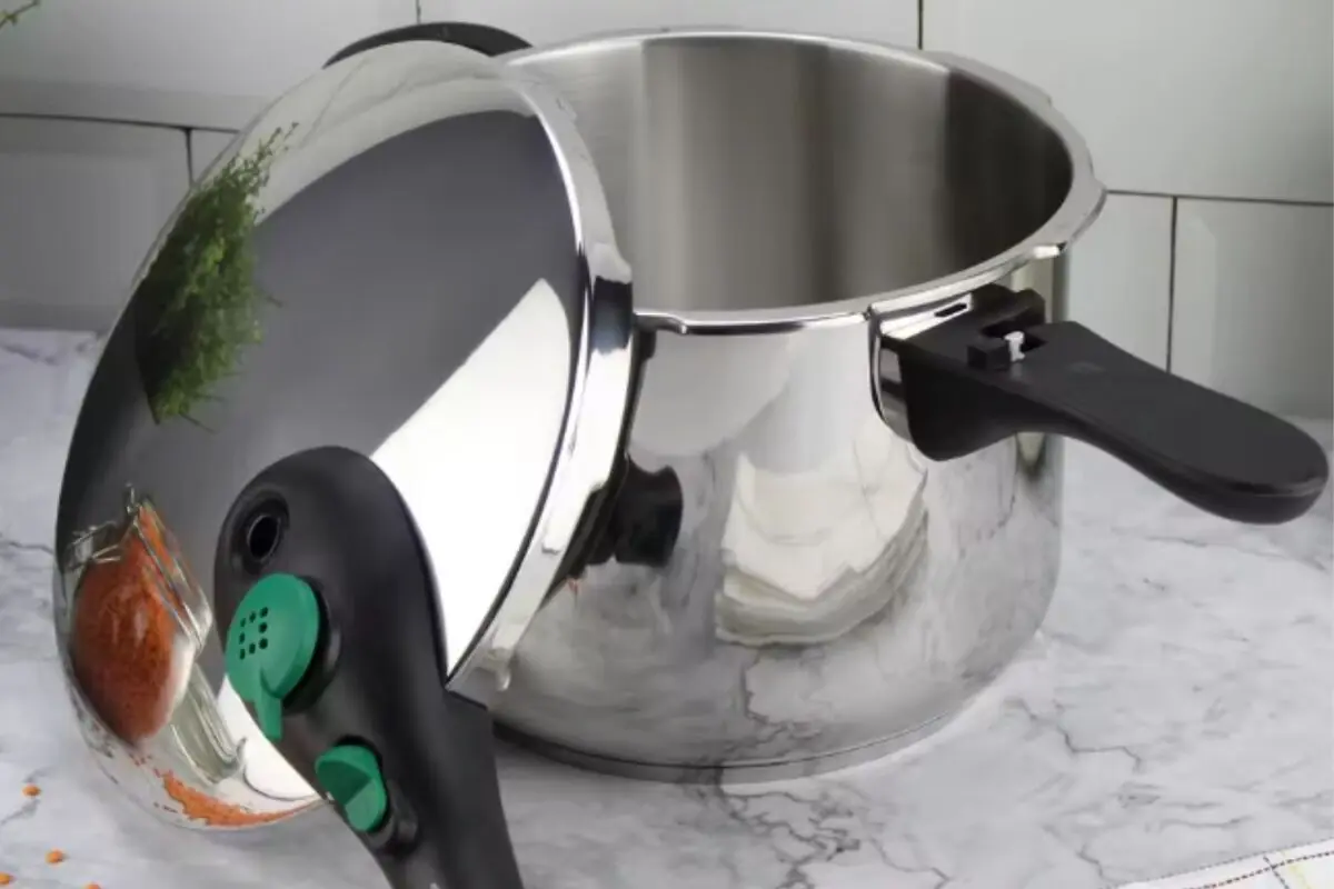 Olla a presión de acero inoxidable abierta sobre una encimera de cocina de mármol