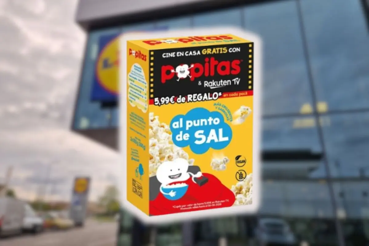 Caja de palomitas Popitas al punto de sal en primer plano frente a la fachada de un supermercado desenfocado