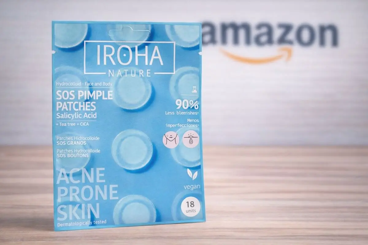 Caja azul de parches hidrocoloides para granos Iroha Nature con ácido salicílico sobre una mesa de madera y el logo desenfocado de Amazon al fondo