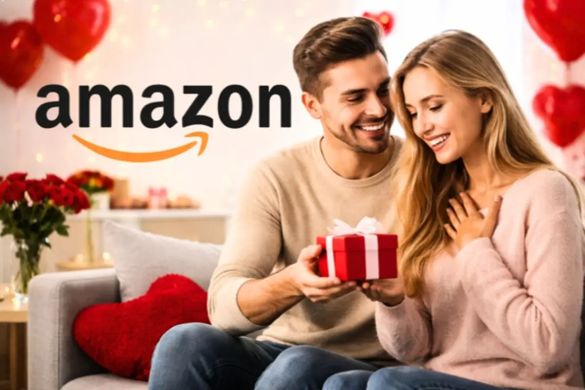 Pareja sonriente intercambiando un regalo rojo en un ambiente romántico con globos y flores y el logo de Amazon al fondo