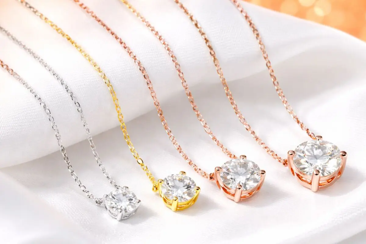 Collares delicados con colgantes de circonia en monturas plateadas doradas y oro rosa sobre tela blanca