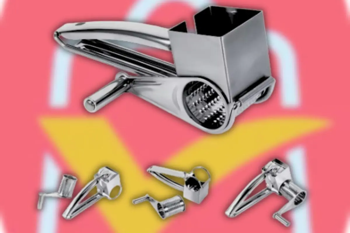 Rallador de queso metálico manual con tambor giratorio y piezas desmontables sobre fondo rosa con flecha amarilla