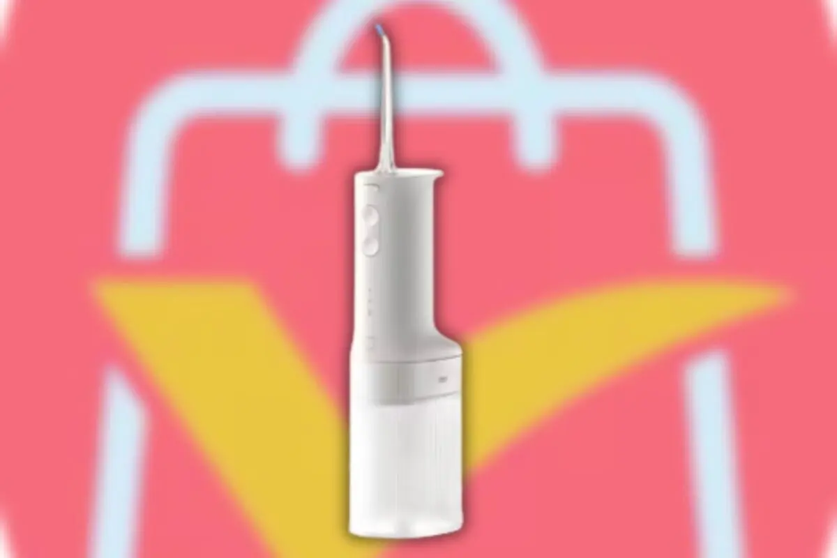 Irrigador dental portátil blanco sobre fondo rosa con icono de bolsa de compras estilizada