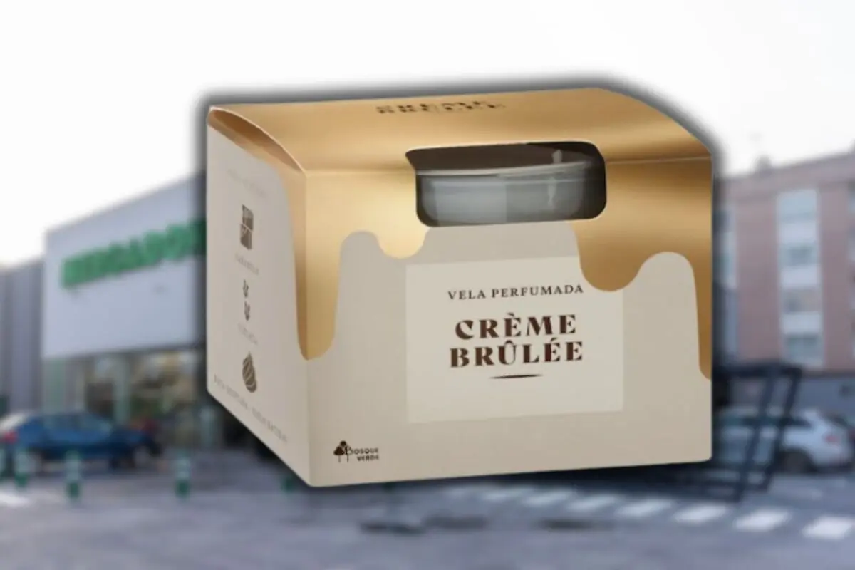 Caja de vela perfumada aroma crème brûlée de la marca Bosque Verde sobre fondo desenfocado de supermercado Mercadona