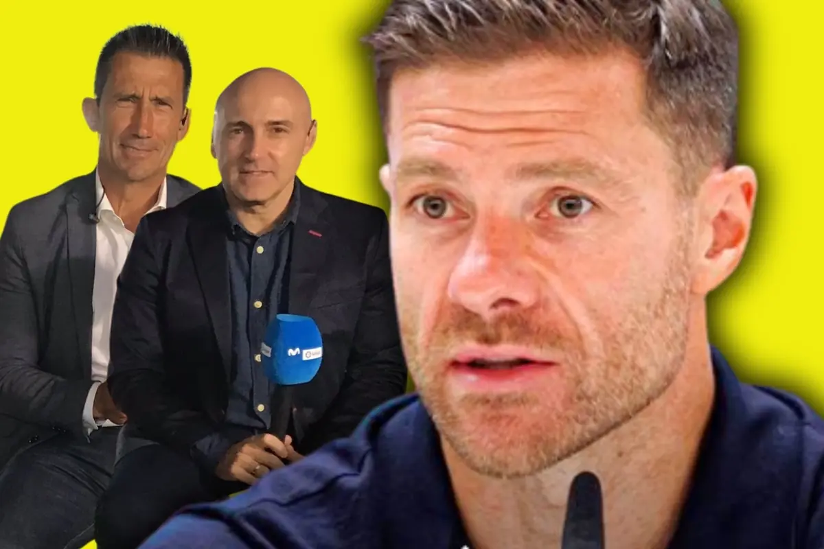 Primer pla d’un home parlant amb un gest seriós mentre al fons apareixen dos presentadors amb micròfon sobre un fons groc cridaner